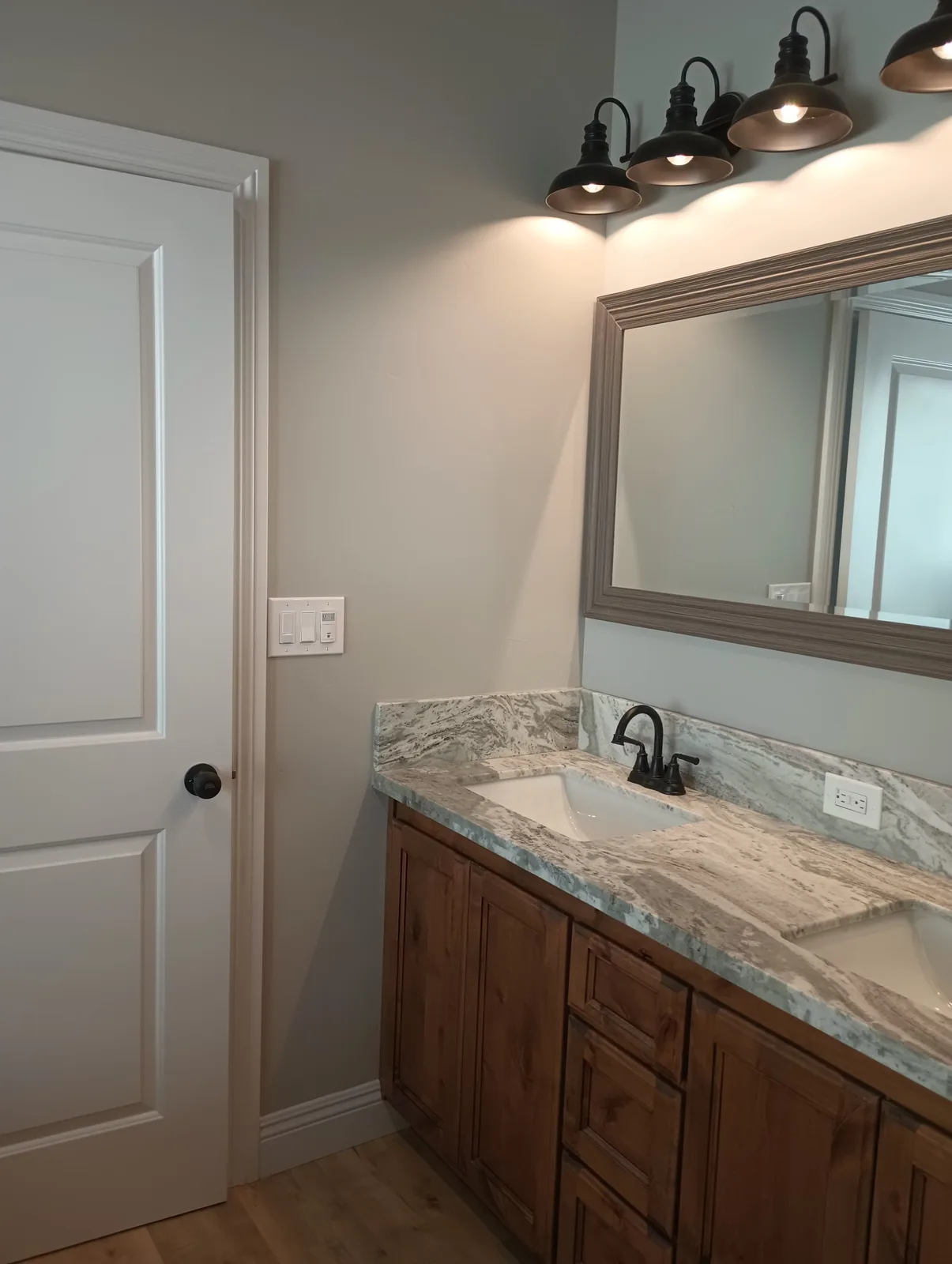 Completed rustic dual-sink vanity with marble top and matte black fixtures