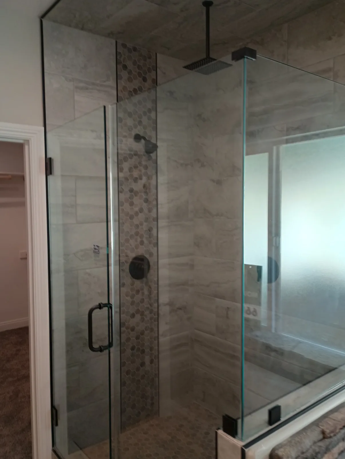 Completed hexagon mosaic shower with a frameless glass enclosure