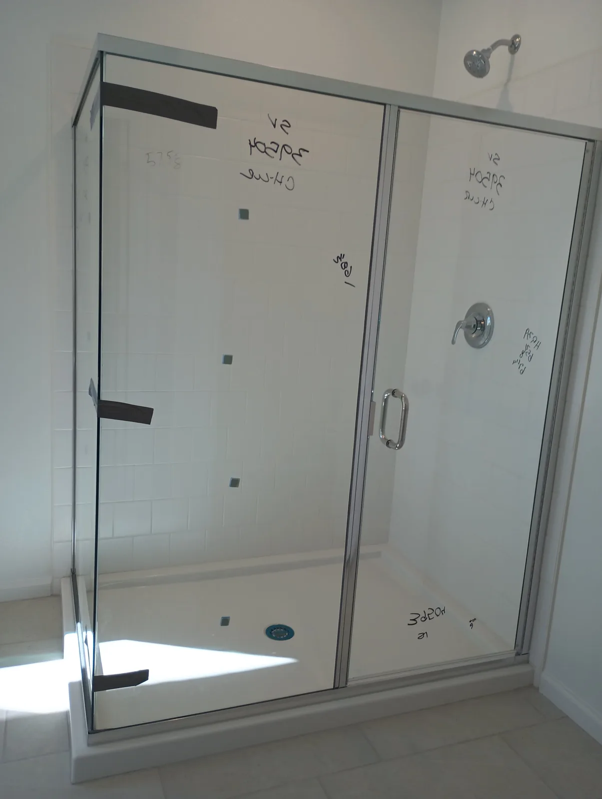 Finished glass enclosure with production measurements marked before final inspection