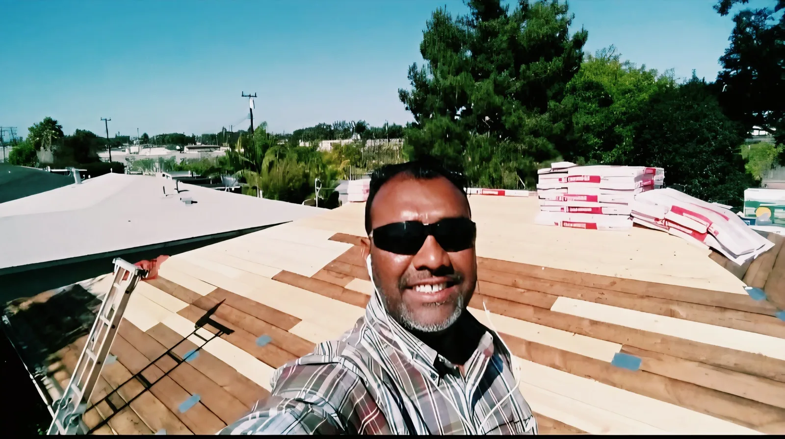 Crew member on a residential rooftop during restoration with new roof decking and insulation visible