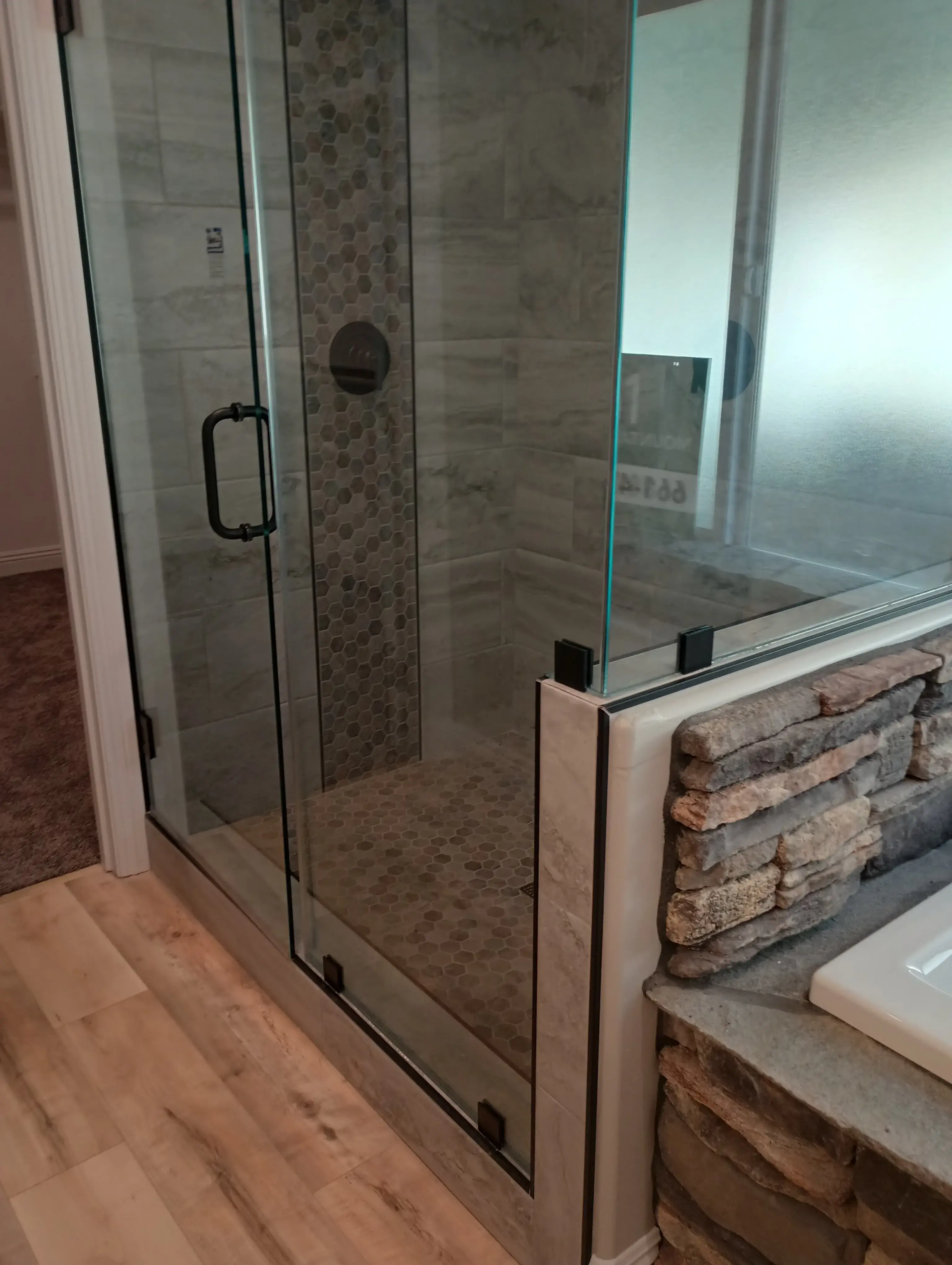 Frameless glass shower enclosure with tile and hardware in place