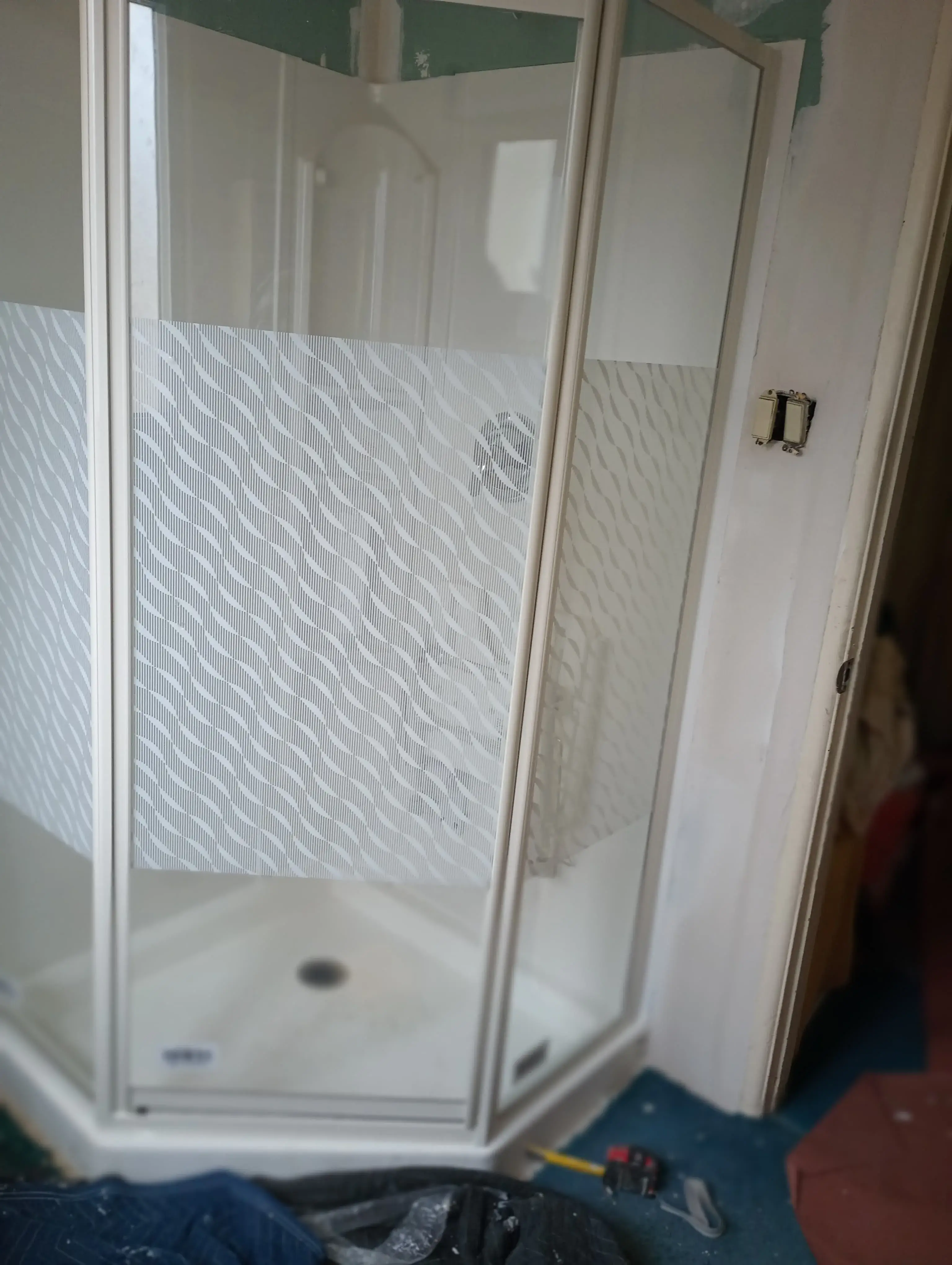 Frosted corner shower enclosure shown during a mid-installation check